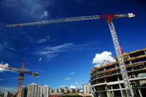 Tower cranes towering over a city skyline, showcasing ongoing urban construction.