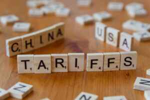 Wooden letter blocks spelling tariffs, China, and USA representing trade relations.