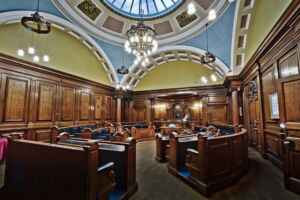 Victorian council chamber in Lancaster Town Hall with elegant wooden decor and skylight.